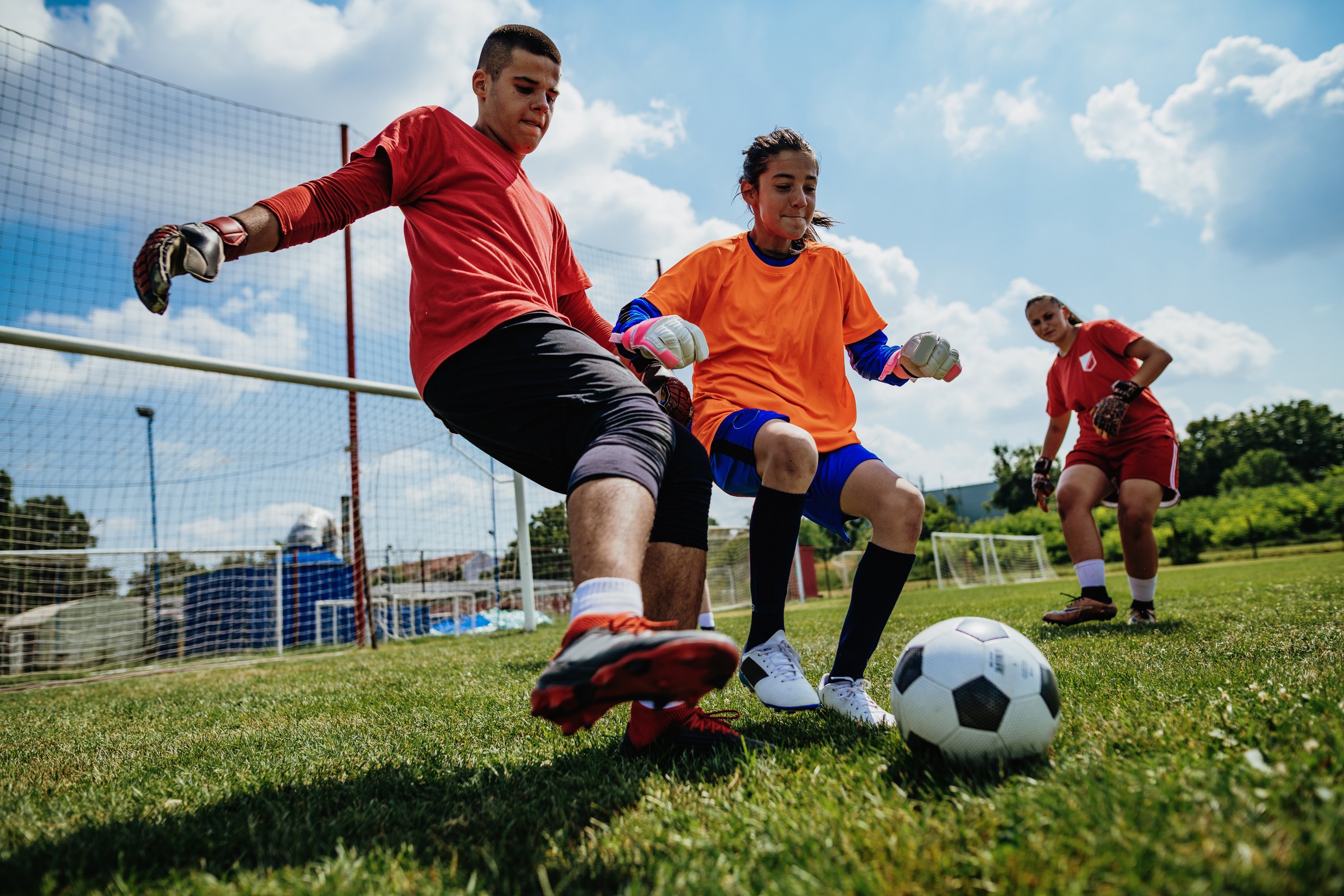 Teens in action - playing soccer and practicing penalty kicks for goalkeepers